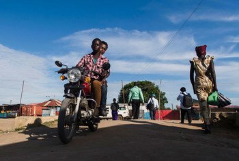 Des personnes à moto et à pied sur une route du Sud-Soudan, près de la MINUSS