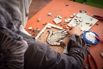 A woman crafts a mosaic depicting a peace dove in the Za’atari refugee camp in Jordan.