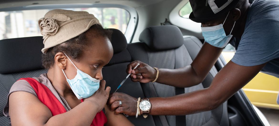 一名残疾妇女在南非德班附近的一家临时诊所接种新冠疫苗。