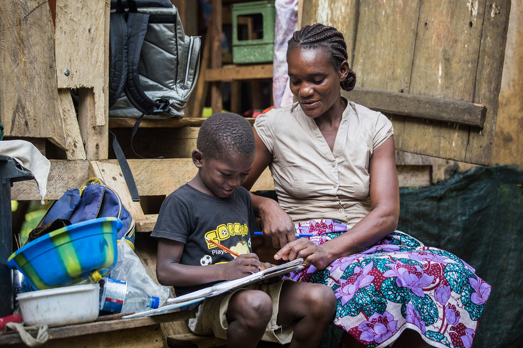 A mother helps her son with his homework in São Tomé and Príncipe.