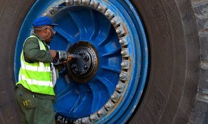 A worker repairs a wheel of a giant haul truck at a uranium mine in Namibia.