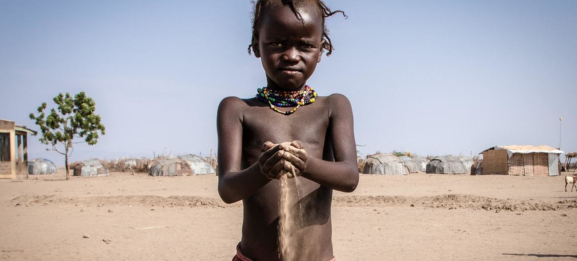 A areia flui da mão de uma criança como se fosse uma ampulheta. No sudoeste da Etiópia, a seca agravada pelas alterações climáticas ameaça plantações e o gado, levando a população ao limite