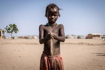 Sand flows from a child's hand like through an hourglass. In southwestern Ethiopia, drought worsened by climate change is threatening crops and livestock, pushing the population to the brink.