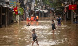 Children play in their neighborhood near the Red River, which is flooded following Typhoon Yagi in September 2024, in Hanoi, Vietnam.