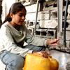 Selin Al-Dada, una niña de Gaza, llena un galón de plástico con agua potable.