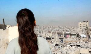 Selin Al-Dada, una niña de Gaza, se encuentra en el tejado de su casa destruida, contemplando la devastación que se extiende por toda la ciudad.
