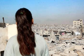 سيلين الددا، طفلة من غزة، تقف على سطح منزلها المدمر، وتنظر إلى الدمار الذي عمّ المدينة.