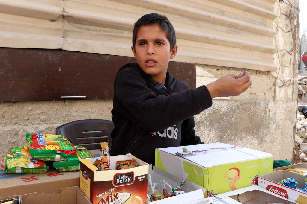 El niño Yousef Nassar vende dulces y galletas a los niños de su barrio para ayudar a sus padres con los gastos.