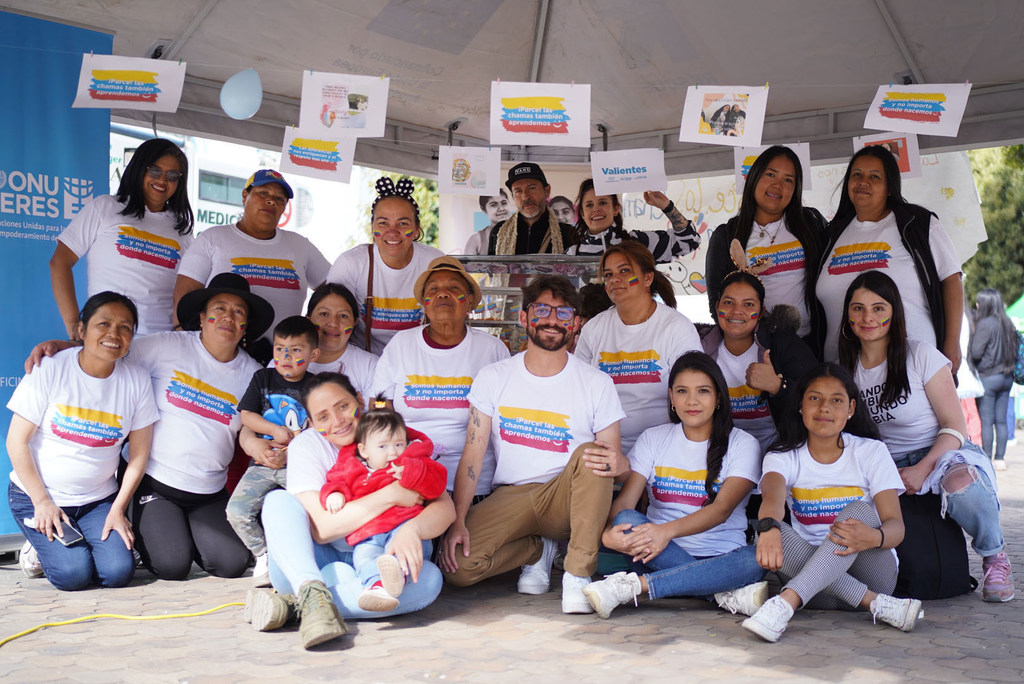 Un grupo de personas, entre ellas Ana Lucía Yama, posan para una foto en un evento en Colombia. Muchos llevan camisetas con el logo del programa "Valientes".