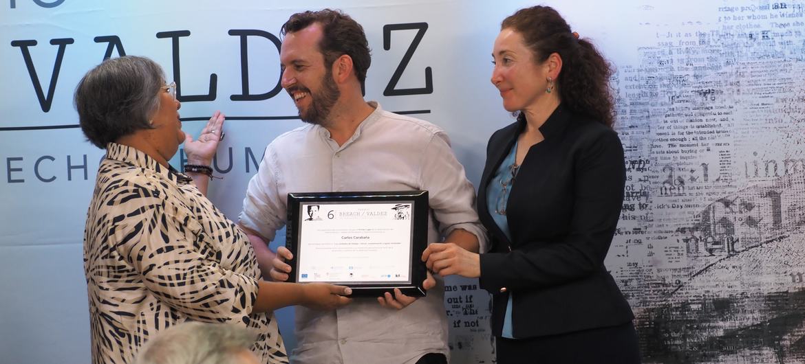 Carlos Carabaña recibe el Premio Breach Valdez de periodismo de manos de dos mujeres en un acto formal en México.