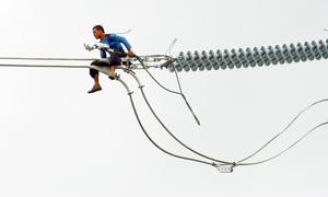 Un trabajador instala un cable de electricidad en Filipinas.