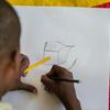 A child displaced by violence in city of Mirebalais, Haiti, draws a picture of their new home.