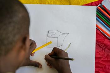 A child displaced by violence in city of Mirebalais, Haiti, draws a picture of their new home.