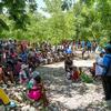 Un trabajador de UNICEF se dirige a un grupo de madres y niños desplazados durante una sesión de sensibilización sobre higiene al aire libre en Haití.