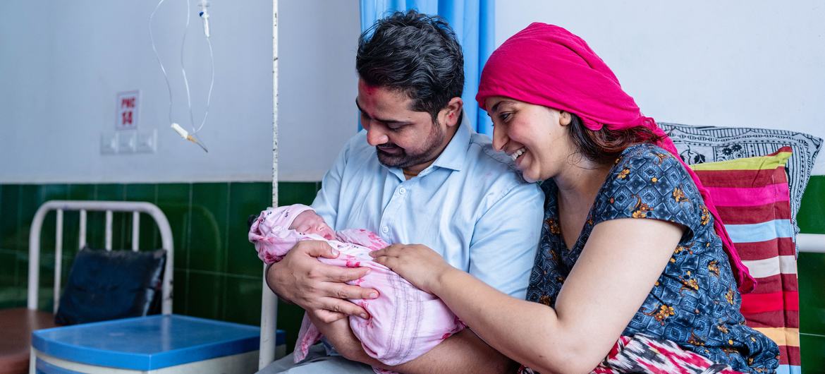 Um recém-nascido com a mãe e o pai em um hospital no oeste do Nepal