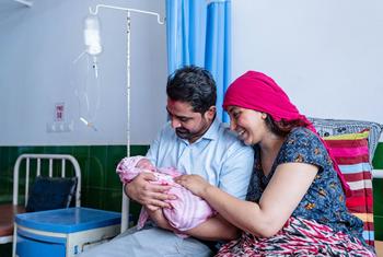Um recém-nascido com a mãe e o pai em um hospital no oeste do Nepal