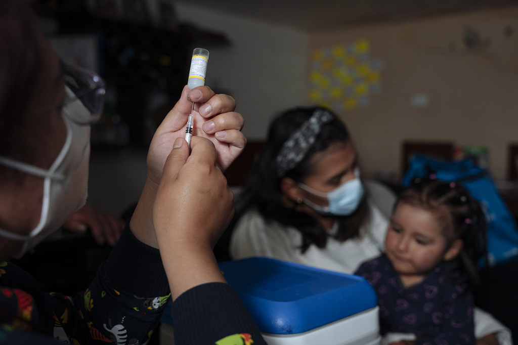 فتاة تبلغ من العمر عامين تتلقى لقاحا في منزلها في الإكوادور