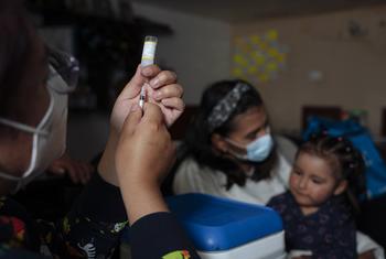 在厄瓜多尔，一名两岁女孩在家中接种疫苗。