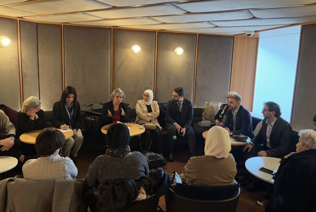 La Sra. Carla Quintana se reúne con un grupo de familias y organizaciones de la sociedad civil en una sala de conferencias.