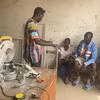 Mwanamume anawafundisha vijana wawili katika warsha huko Banjul, Gambia.