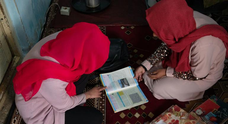 在被剥夺继续在校学习的权利后，一名阿富汗女孩只能在父亲的帮助下在家学习。