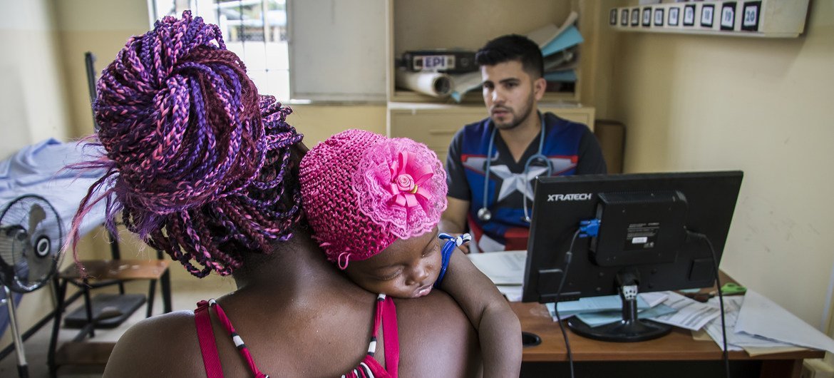 Un médico atiende a una madre y su bebé en Ecuador.
