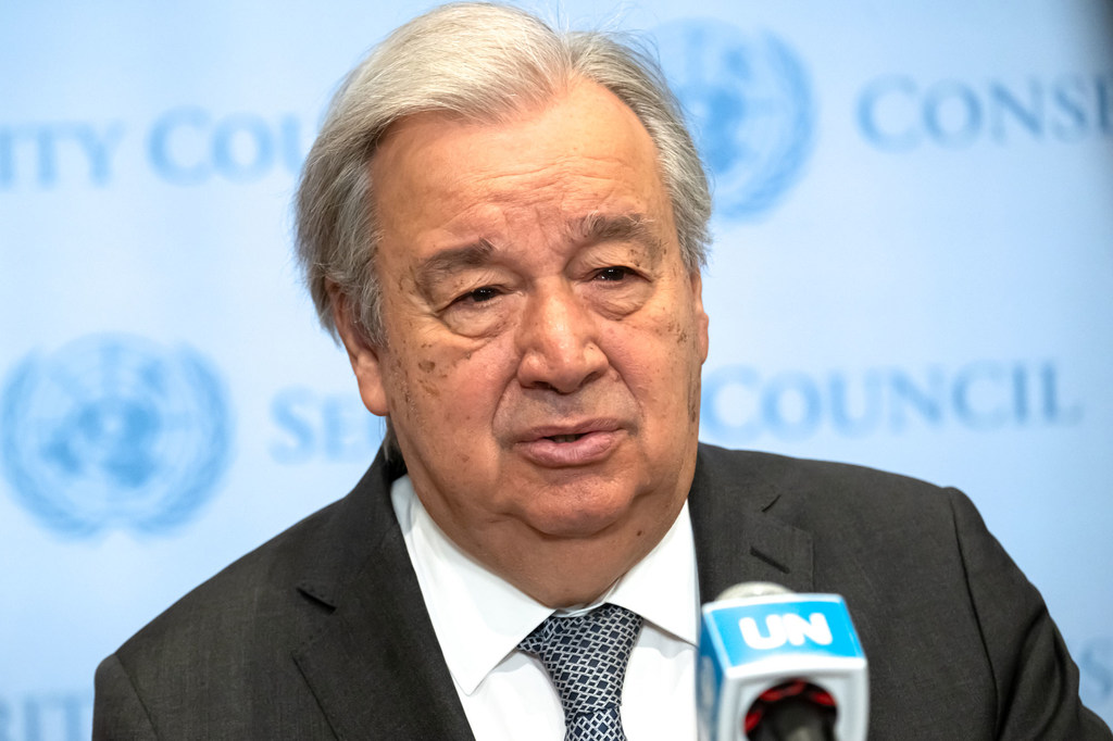 El secretario general de la ONU, António Guterres, hablando en una rueda de prensa con un micrófono con el logotipo de la ONU frente a un telón de fondo del Consejo de Seguridad de la ONU .