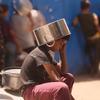 Un enfant se protège du soleil en attendant de recevoir de la nourriture à Gaza.