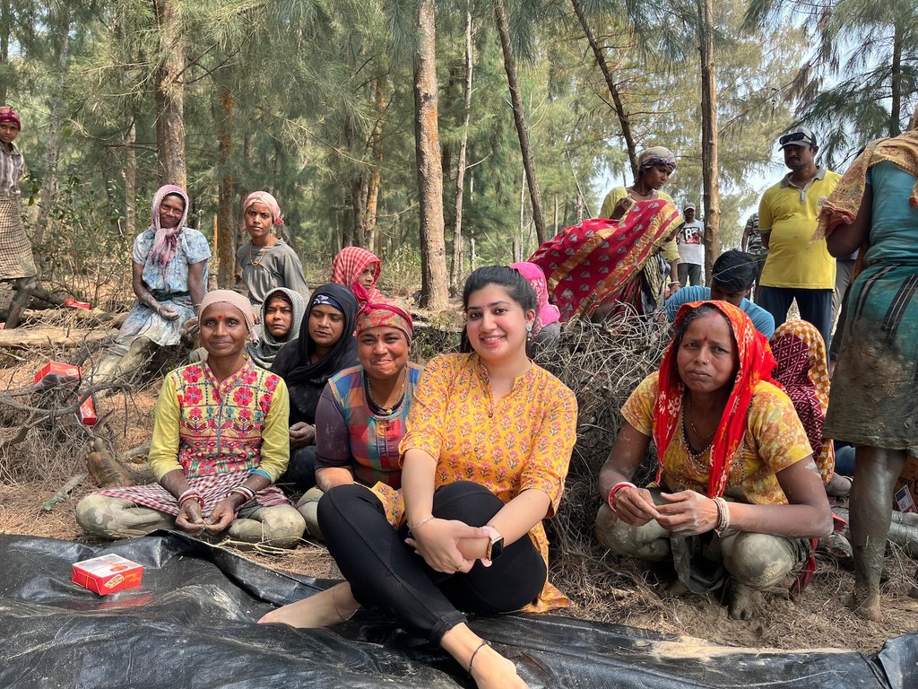 UNDP की परियोजना सहयोगी उर्जस्वी, एक वन क्षेत्र में महिलाओं के एक समूह के साथ बैठी हैं।