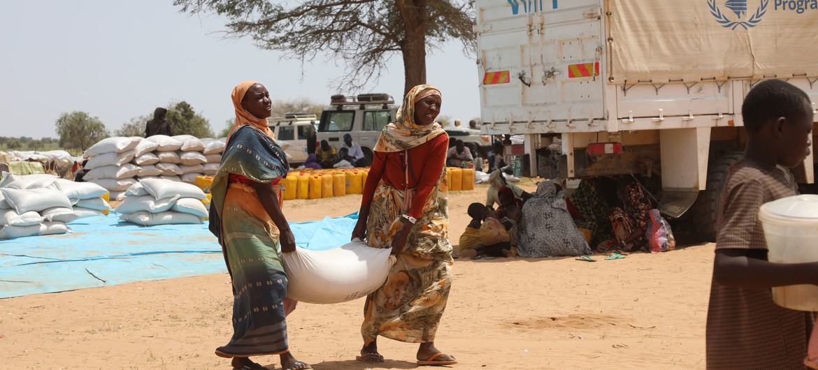 Sudanlı mülteciler, Çad'daki Zabout mülteci kampında gıda yardımı topluyor.