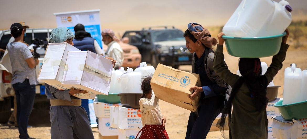 Children carry WFP food rations in a makeshift camp for displaced people in Marib, Yemen.
