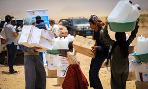 Children carry WFP food rations in a makeshift camp for displaced people in Marib, Yemen.