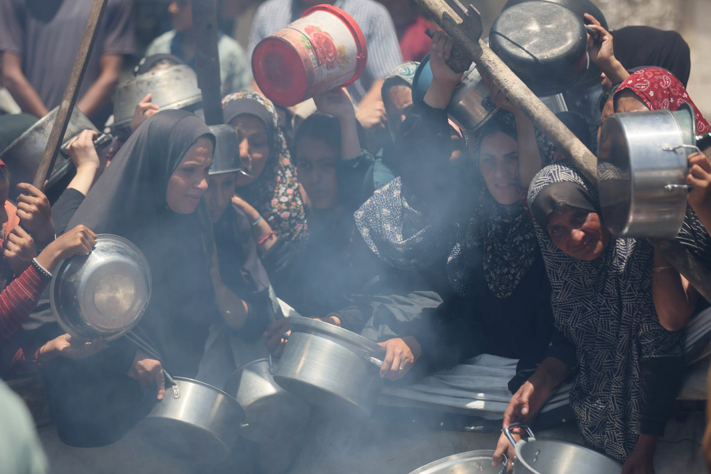 نساء غزة ينتظرن الحصول على الطعام، في ظل انتشار الجوع وشح المساعدات والإمدادات في القطاع.