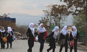 Meninas caminham pela estrada em um bairro hazara no Afeganistão