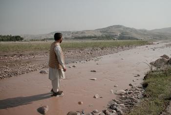 يقف هداية الله سابي من مكتب الأمم المتحدة المعني بالمخدرات والجريمة في مجرى "النهر الأحمر" الجاف في المنطقة الشرقية من أفغانستان.