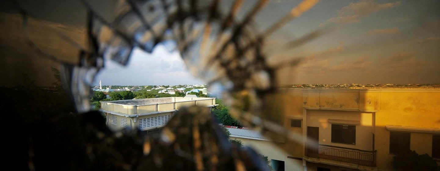 Vue de la banlieue nord de Mogadiscio, en Somalie, à travers la vitre d'un hôtel brisée par une balle.