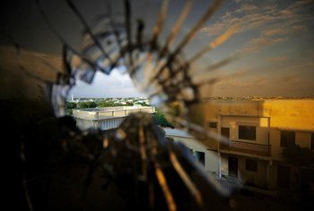The skyline beyond the northern suburbs of Mogadishu is seen through a bullet hole in the window of a hotel in Somalia.