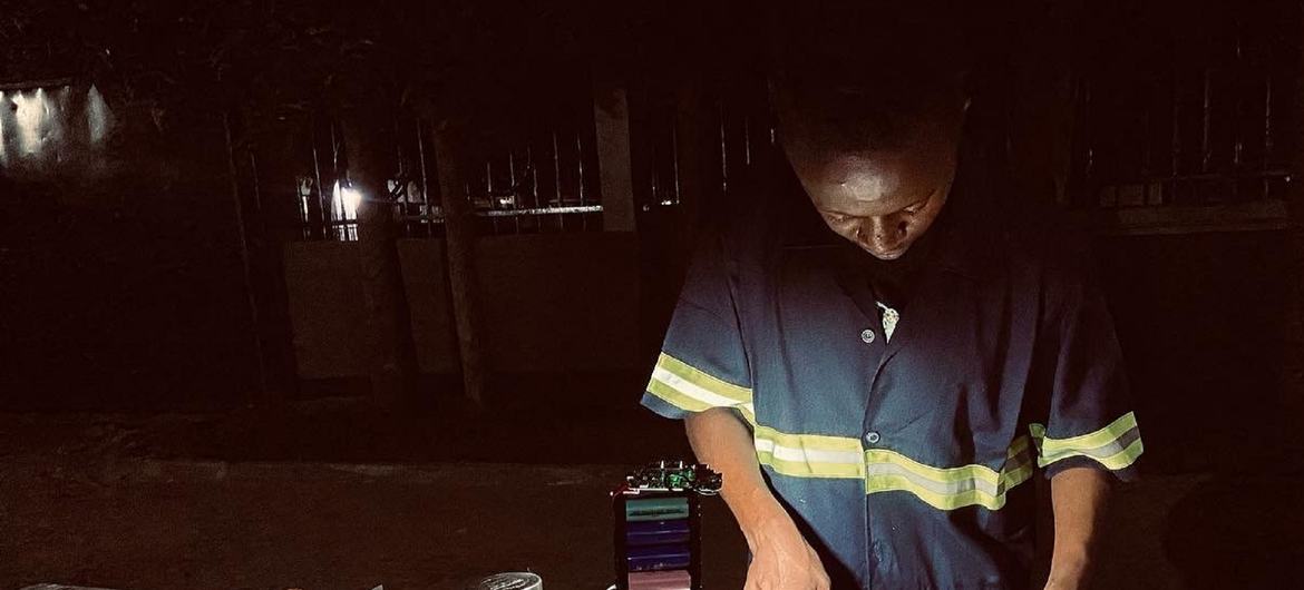 Gibson Kawago, de la promotion 2022 des Jeunes Leaders pour les SDG, travaille dans son atelier où il recycle et réutilise des batteries d'ordinateurs portables usagées.