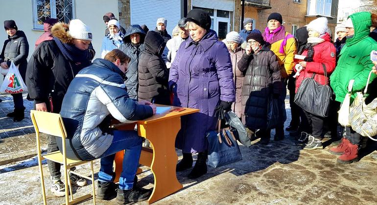 تقف النساء الهاربات من مناطق القتال في إقليمي دونيتسك ولوهانسك في طابور لتلقي المساعدات الإنسانية.