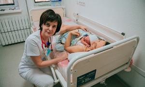 A doctor visits a woman who has just given birth at a hospital in Kharkiv during the conflict in Ukraine.