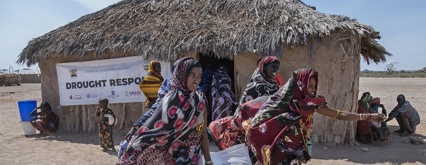 在肯尼亚北部的马萨比特，妇女们从粮食署的分发地点搬运食物。