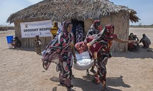 Women carry food from a WFP distribution site in Marsabit County in northern Kenya.