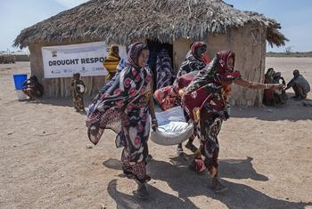 Women carry food from a WFP distribution site in Marsabit County in northern Kenya.