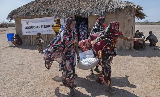 在肯尼亚北部的马萨比特，妇女们从粮食署的分发地点搬运食物。