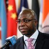 Tété António, Observador Permanente da União Africana junto das Nações Unidas, fala ao microfone da ONU durante uma conferência de imprensa, tendo várias bandeiras como pano de fundo.