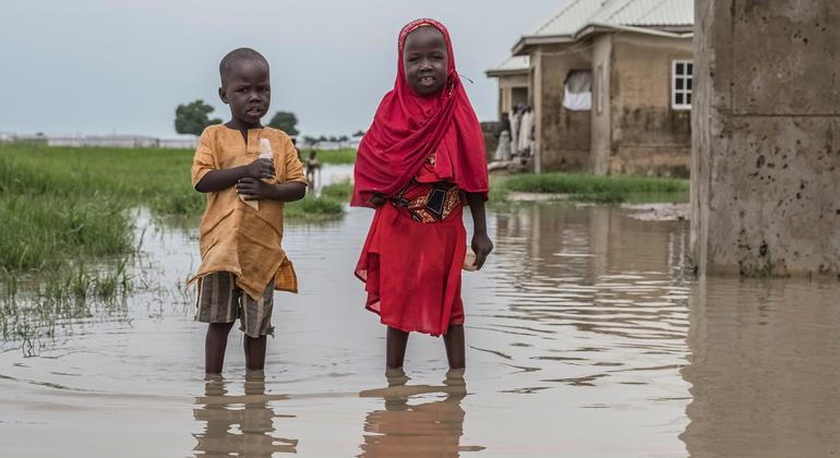 Children stand in a flood water in Borno State, Nigeria. Many children there suffer from acute malnutrition. 