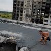 Em Kharkiv, na Ucrânia, um homem inspeciona danos no telhado de um complexo de apartamentos destruído por artilharia e ataques aéreos