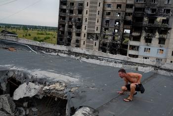 In a suburb in Kharkiv, Ukraine, a man inspects damage on the roof of an apartment complex destroyed by artillery and air strikes.