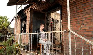 A pregnant woman sits outside what remains of her home after it caught fire during heaving shelling in Shybene, Kyiv Oblast, Ukraine.