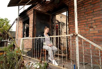 A pregnant woman sits outside what remains of her home after it caught fire during heaving shelling in Shybene, Kyiv Oblast, Ukraine.